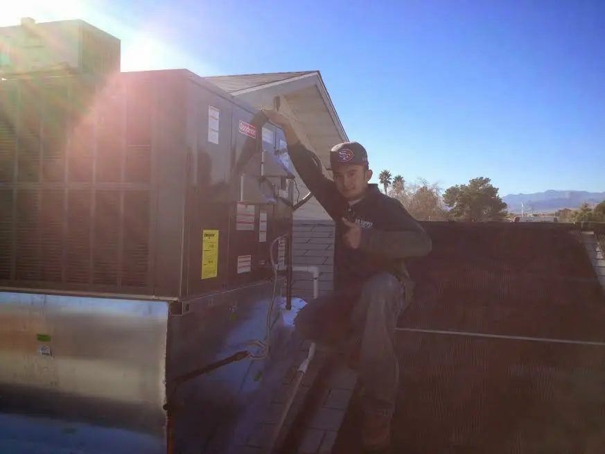 HVAC technician performing HVAC Inspection on a rooftop unit in McPherson